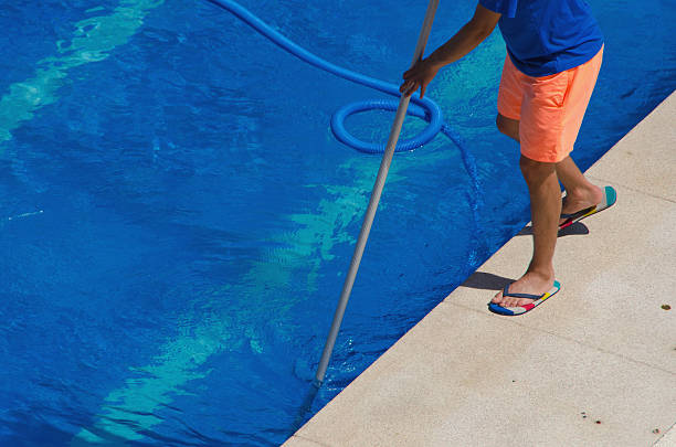 man cleaning a pool for safest possible swimming conditions