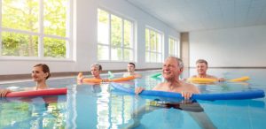 group of people doing low impact workouts in a pool to stay fit